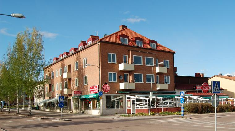 Nises– och Mases från ingången till Mårtas livs, nuvarande ICA. Byggnadens lågmälda tegelfasader är ett uttryck för den återhållsamma modernism som förekom i Leksand under 1950–talet.