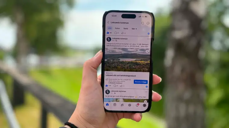 En mobil i fokus som visar Leksands kommuns officiella facebooksida.