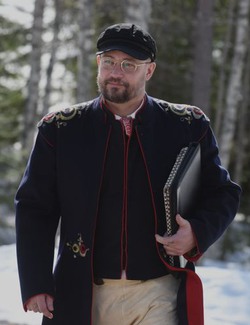 Porträttbild på Micael Kans Lodén, klädd i Leksandsdräkt.